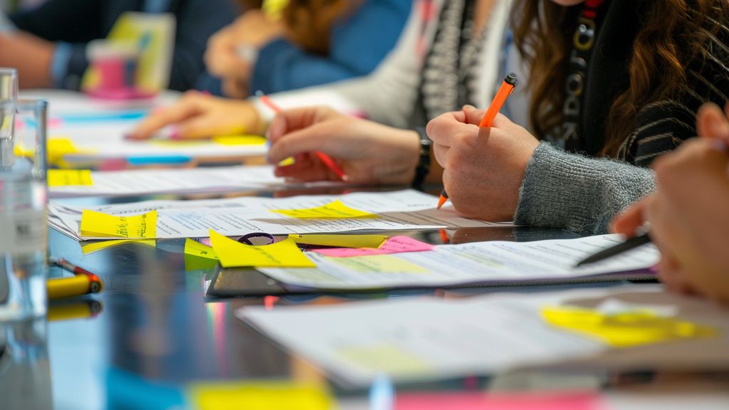 Audience feedback forms being reviewed, with notes and suggestions highlighted in bright colors.